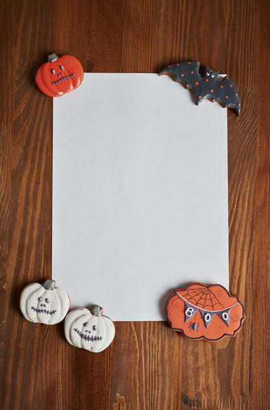 Different Halloween Cookies Are Placed on Corners of Sheet of Paper